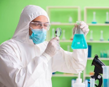 Laboratuvarda yeni bir deney üzerinde çalışan kimyager.