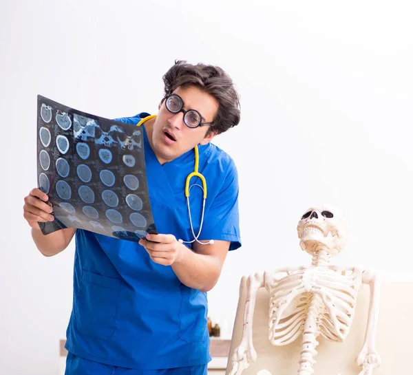 Funny doctor with skeleton in hospital — Stock Photo, Image