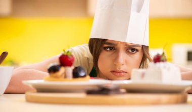 Genç aşçı mutfakta kek pişiriyor.