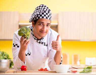 Genç profesyonel aşçı evde salata hazırlıyor.