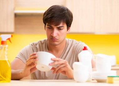 Adam evde bulaşık yıkıyor.