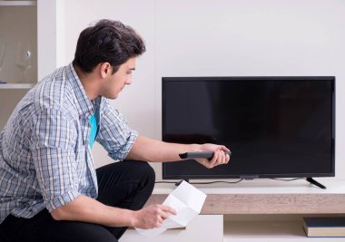 Bozuk televizyonu tamir etmeye çalışan adam