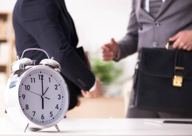 Acil ve son teslim tarihi konseptinde alarm veren bir işadamı.