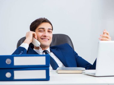 İşadamı ofis telefonundan konuşuyor.