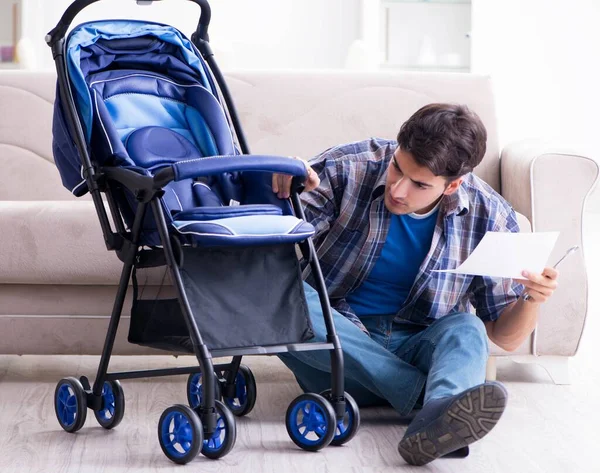 Ung far monterar barnvagn hemma — Stockfoto