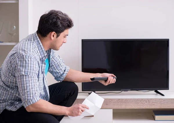 Homem tentando corrigir tv quebrado — Fotografia de Stock