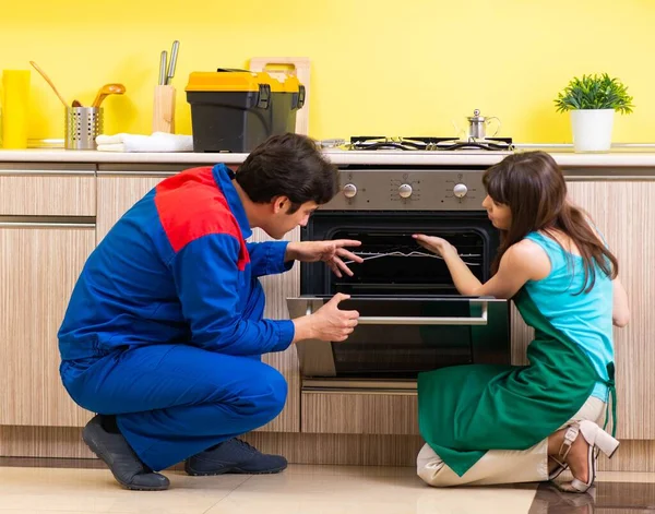 Donna con imprenditore in cucina discutendo di riparazione — Foto Stock