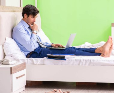 Otel odasında fazla mesai yapan bir iş adamı.