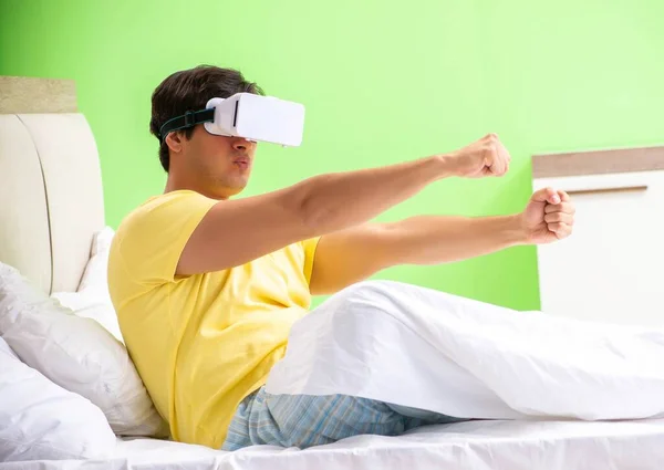 Jongeman met virtuele bril in de slaapkamer — Stockfoto