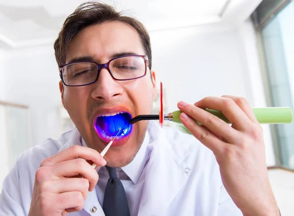 Divertido dentista con luz de curado en concepto médico —  Fotos de Stock