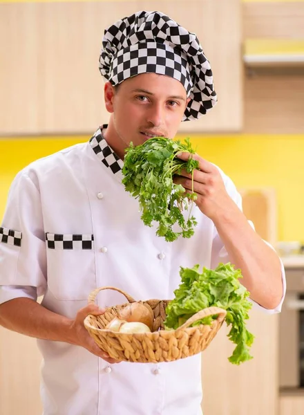 Jovem cozinheiro profissional preparando salada na cozinha — Fotografia de Stock