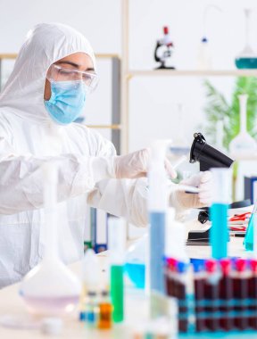 Laboratuvarda kimyasallar üzerinde çalışan genç bir kimyager.