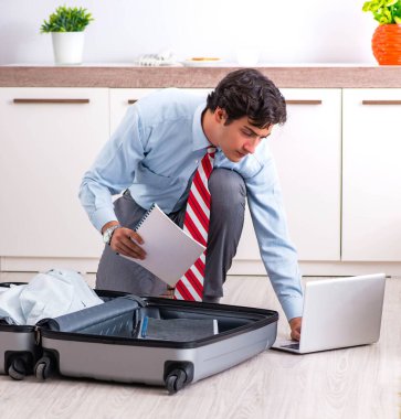 Genç yakışıklı iş adamı yolculuğa hazırlanıyor.