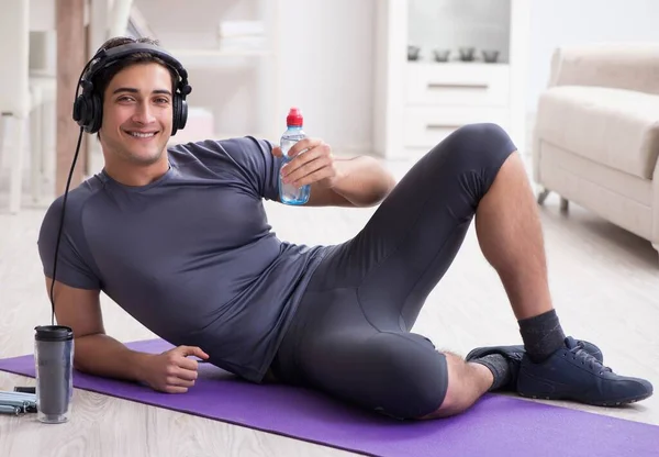 Man doing sports at home and listening to music