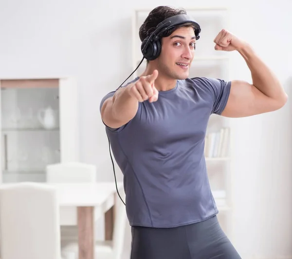 Adam evde spor yapıyor ve müzik dinliyor. — Stok fotoğraf