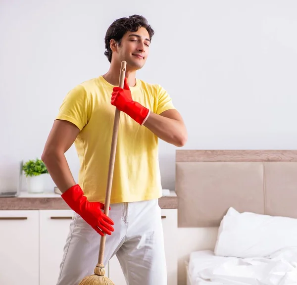 Jeune homme beau nettoyage dans la chambre — Photo