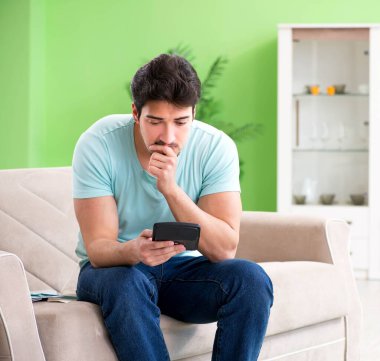 Genç adam kişisel finans ve faturalarla boğuşuyor.