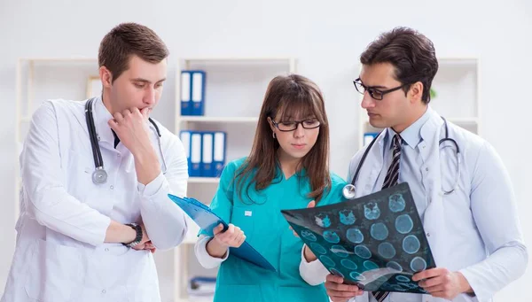 Tres médicos discutiendo los resultados de la exploración de la imagen de rayos X — Foto de Stock