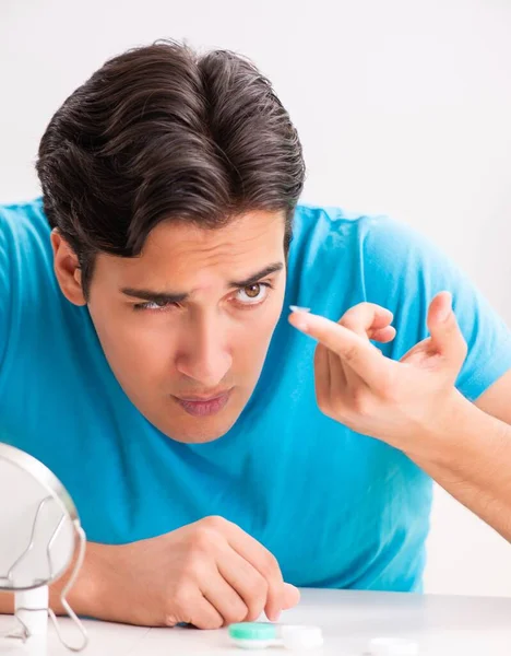 Hombre tratando de lentes de contacto en casa — Foto de Stock