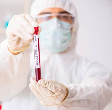 Genç yakışıklı laboratuvar asistanı hastanede kan örnekleri test ediyor.