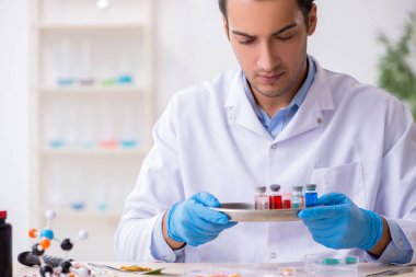 Uyuşturucu sentezi konseptinde genç erkek laboratuvar asistanı