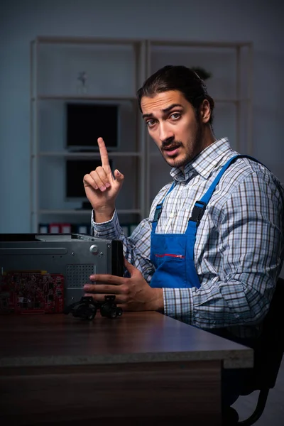 Junger Techniker repariert nachts Computer in Werkstatt — Stockfoto