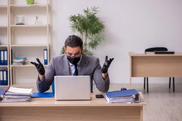 Jonge mannelijke werknemer op kantoor tijdens pandemische ziekte — Stockfoto