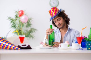 Genç adam doğum gününü evde kutluyor.