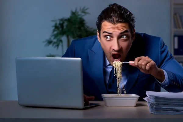 Funcionário com fome trabalhando até tarde no escritório — Fotografia de Stock