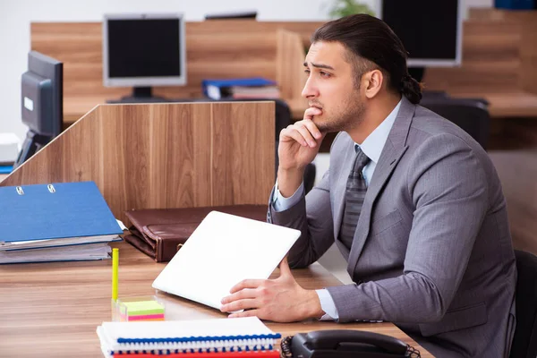 Joven empleado masculino infeliz con el trabajo excesivo —  Fotos de Stock