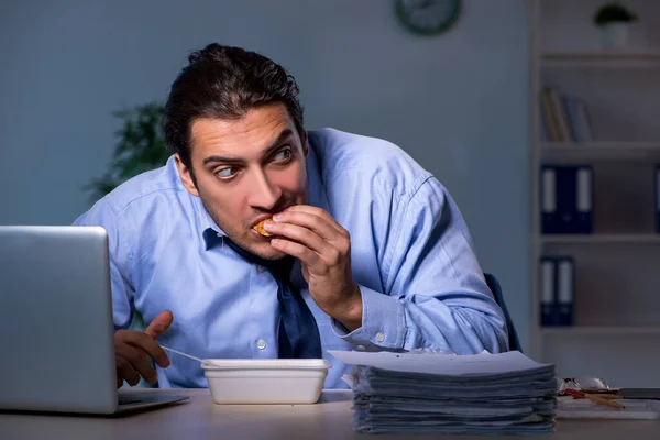 Empleado hambriento trabajando hasta tarde en la oficina — Foto de Stock