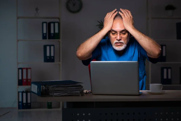 Geceleri hastanede yaşlı bir erkek doktor. — Stok fotoğraf