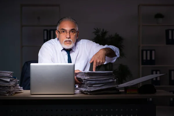 Viejo empleado trabajando hasta tarde en el lugar de trabajo — Foto de Stock