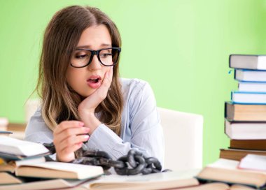 Genç kız öğrenci masaya zincirlendi ve sınavlara hazırlanıyor.