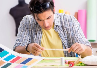 Atölyesinde çalışan genç terzi.