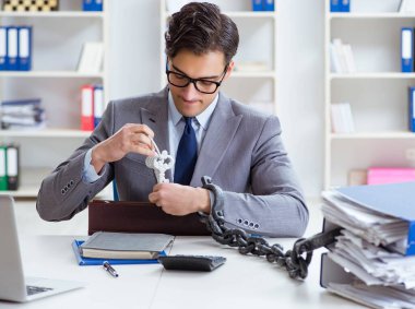 Ofis masasına zincirlenmiş meşgul bir çalışan.