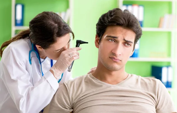 Médico femenino revisando pacientes oído durante examen médico —  Fotos de Stock