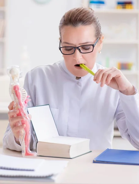 Kvinna läkare studerar mänskligt skelett — Stockfoto