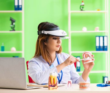 Diş implantı üzerinde çalışan kadın dişçi.