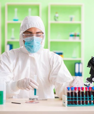 Laboratuvarda yeni bir deney üzerinde çalışan kimyager.