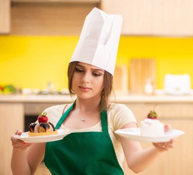 Genç aşçı mutfakta kek pişiriyor.