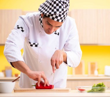 Genç profesyonel aşçı evde salata hazırlıyor.