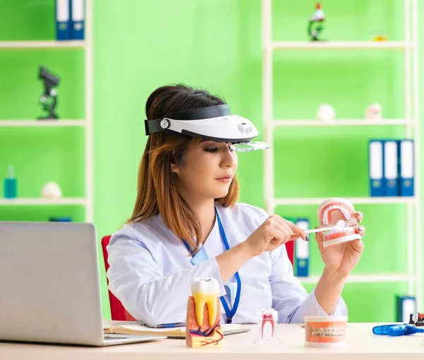 Diş implantı üzerinde çalışan kadın dişçi.