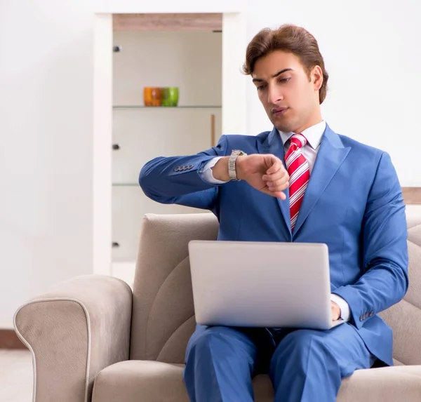 Joven hombre de negocios trabajando en casa sentado en el sofá — Foto de Stock