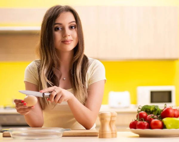 Jonge vrouw bereidt salade thuis in de keuken — Stockfoto