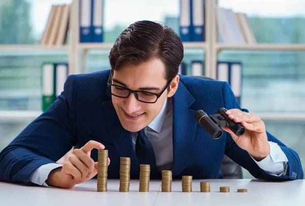 Affärsman med staplar av mynt på kontoret — Stockfoto