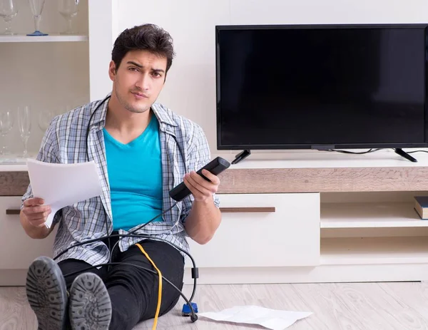 Man trying to fix broken tv — Stock Photo, Image