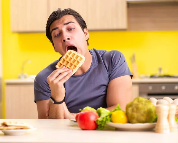 Homem tendo escolha difícil entre alimentos saudáveis e não saudáveis — Fotografia de Stock