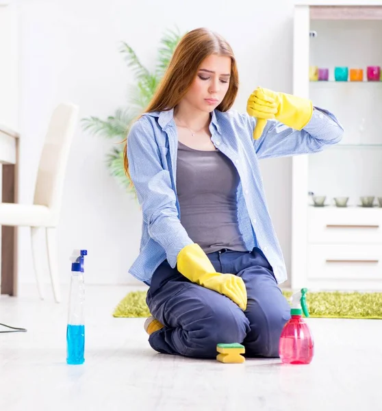 Junge Frau putzt Fußboden zu Hause und erledigt Hausarbeiten — Stockfoto