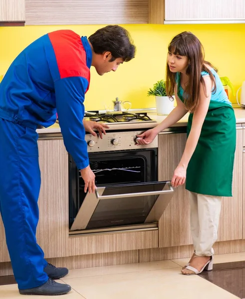 Woman with contractor at kitchen discussing repair — Stock Photo, Image